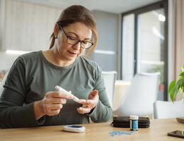 A woman checks her blood sugar.