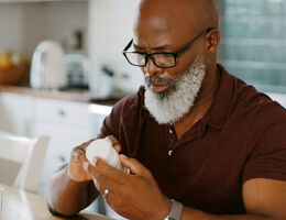 A man reads the label on a medication bottle