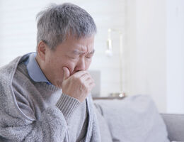 A man covers his cough.